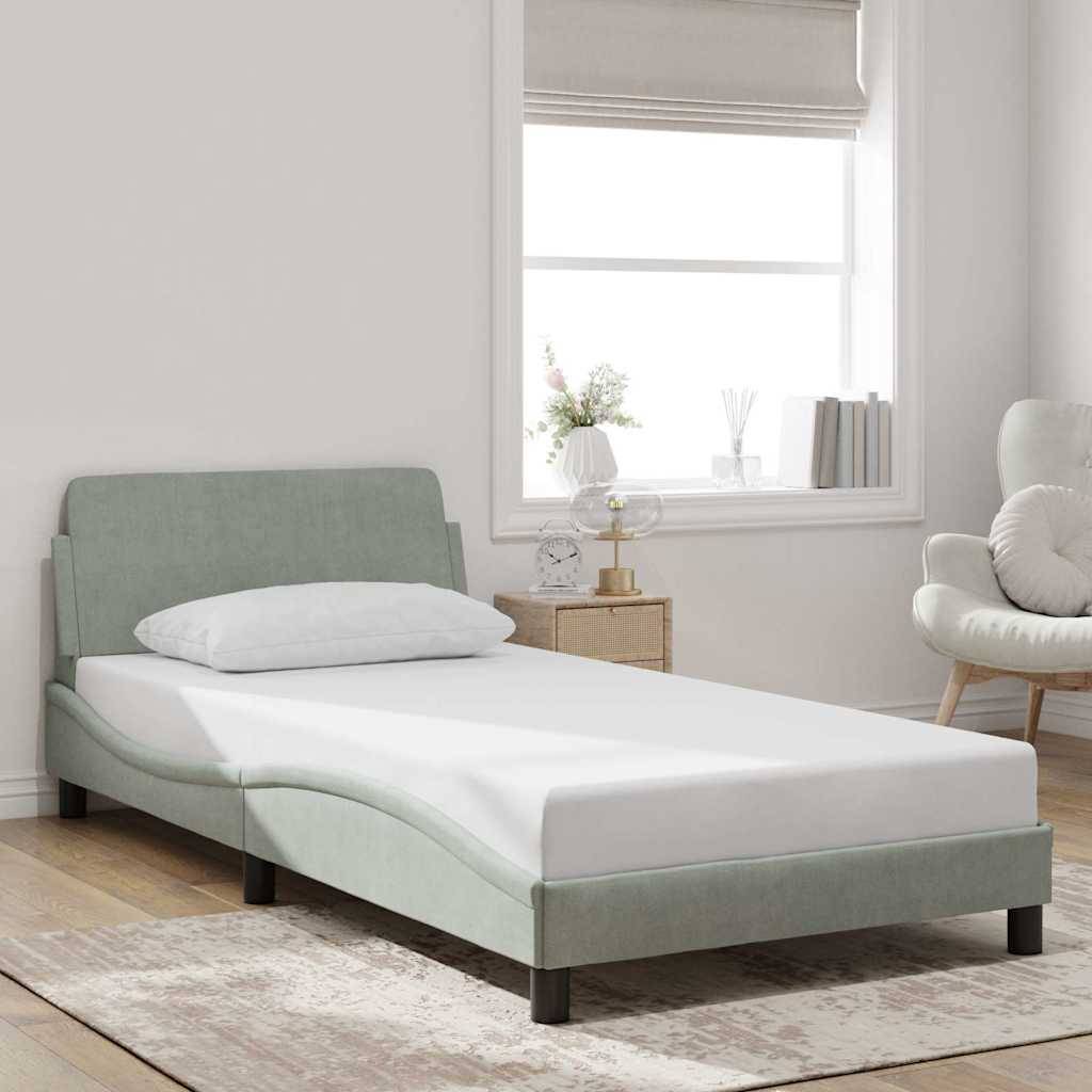 Mintgrünes gepolstertes Einzelbett in einem hellen, minimalistischen Schlafzimmer mit weißer Bettwäsche, Teppich, Nachttisch und Fenster.