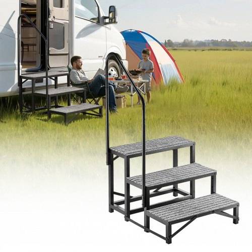 Schwarze dreistufige Klapptreppe für Wohnmobile von vorne gezeigt, mit einem Wohnwagen und Campern auf einem grasbewachsenen Feld im Hintergrund.