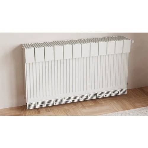 Weißer wandmontierter elektrischer Heizkörper mit vertikalen Paneelen und belüftetem Sockelleistengitter auf einem Holzboden gegen eine einfache Wand.