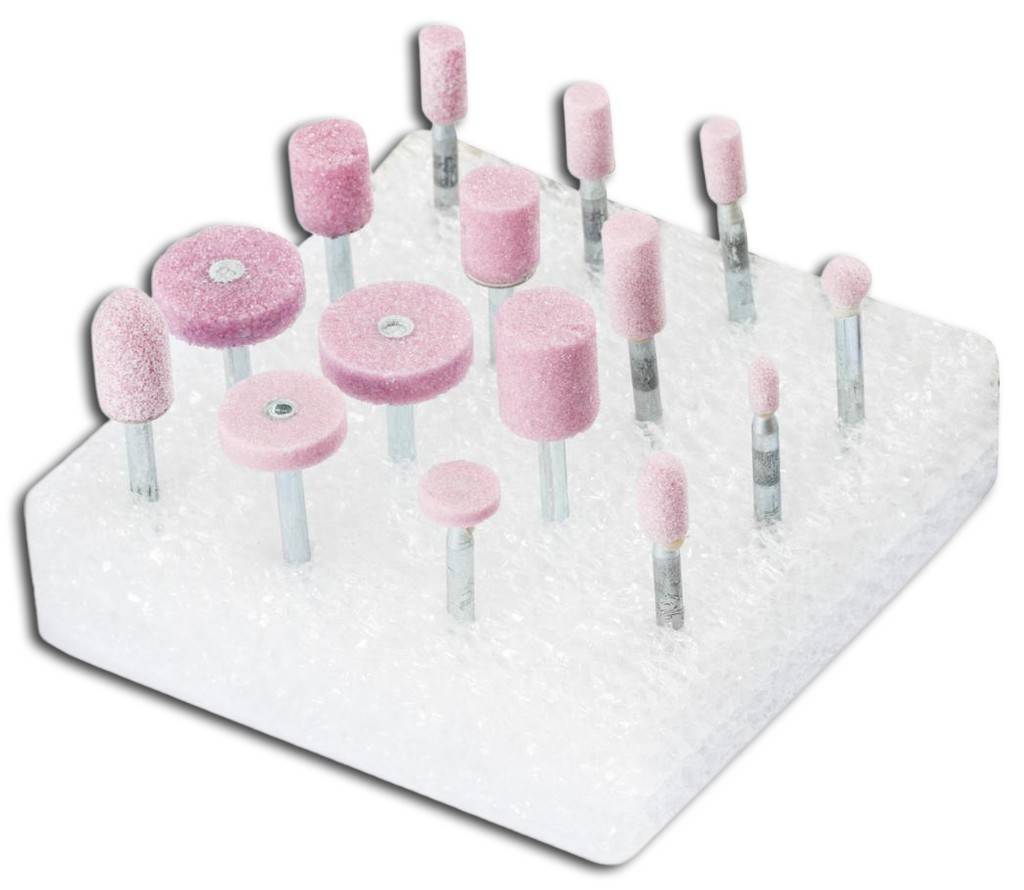 Sortierte rosa Schleif- und Polierbits mit Schleifer-Aufsätzen in einem Schaumstoff-Displayblock, dargestellt als produktstilisiertes Bild.