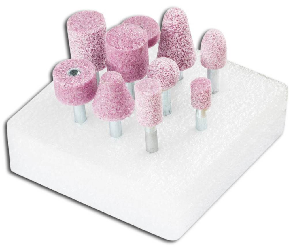 Sortierte rosa Schleifsteine und montierte Schleifmittel auf einem weißen Ausstellungsblock, wahrscheinlich für Polier- oder Schleifwerkzeuge.