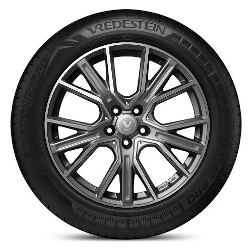 Studioproduktfoto eines schwarzen Autoreifens mit silberner mehrsprechiger Leichtmetallfelge auf dunklem Hintergrund, Marke Vredestein.