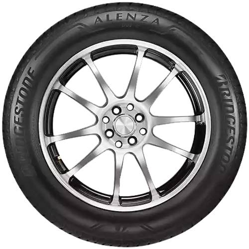 Ein Bridgestone Alenza-Reifen, montiert auf einer silbernen Leichtmetallfelge mit mehreren Speichen, frontal vor schwarzem Hintergrund dargestellt.