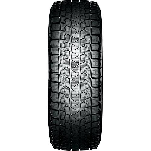 Nahaufnahme einer Autoreifen-Lauffläche auf schwarzem Hintergrund, die ein detailliertes Wintermuster für Bodenhaftung zeigt.