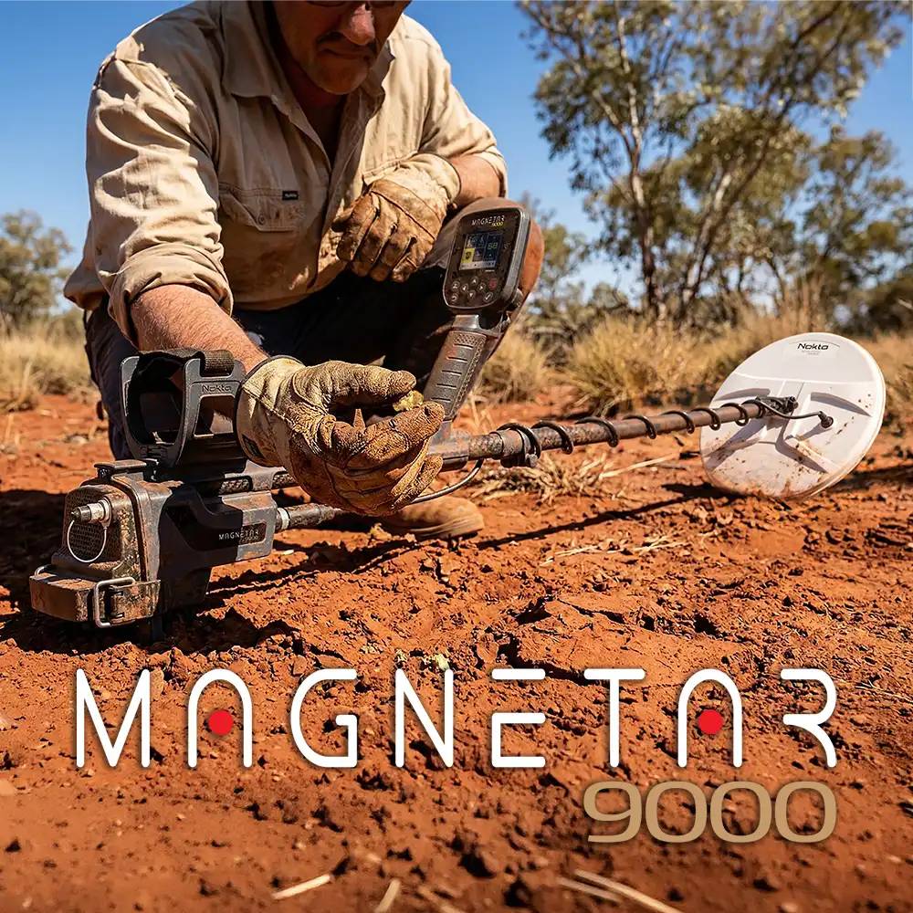 Person kniet im Freien und benutzt einen Metalldetektor auf rotem Boden; der Produkttext lautet „MAGNETAR 9000