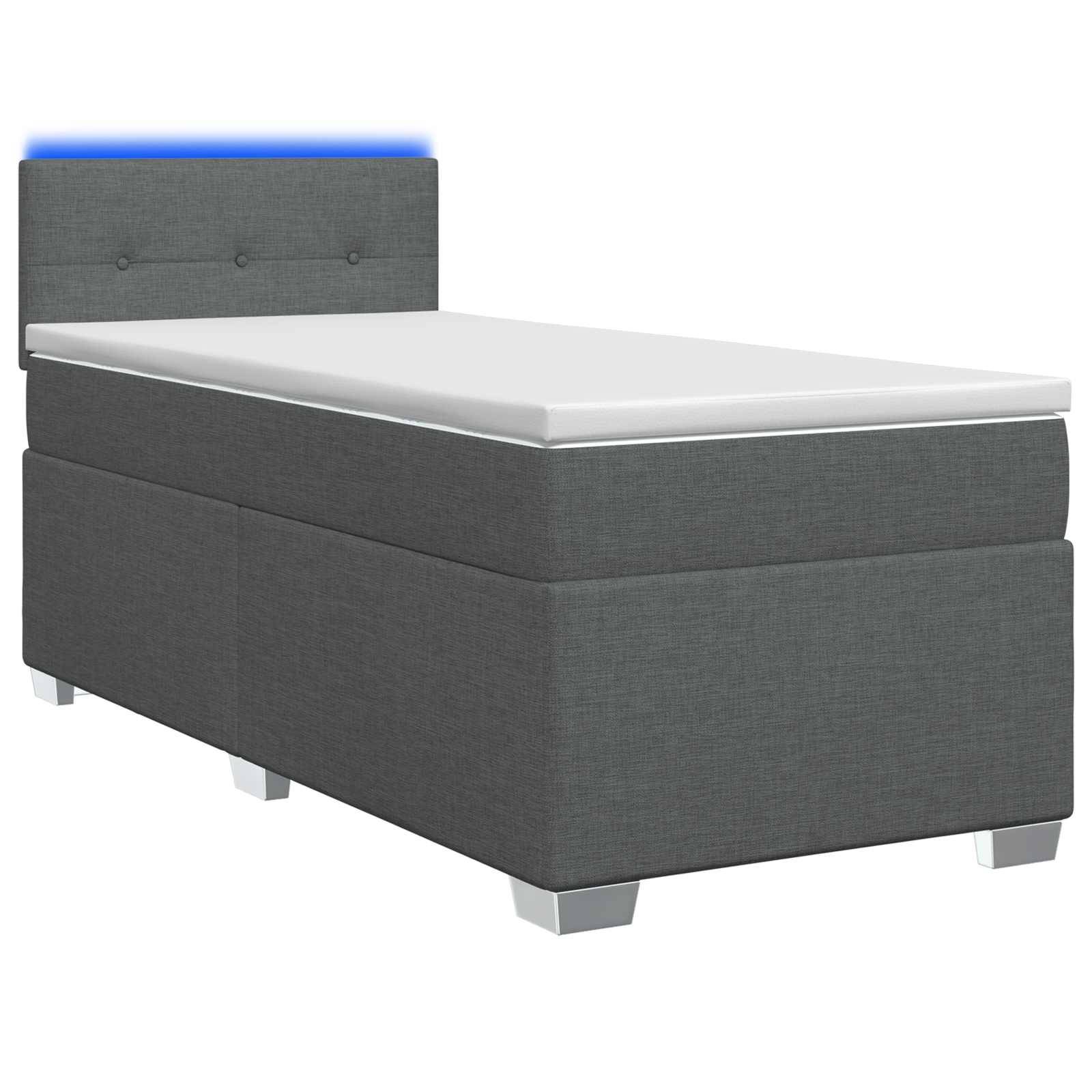 Grau gepolstertes Einzelbett mit weißer Matratze und blau beleuchteter Kopfwand, gezeigt auf weißem Hintergrund.