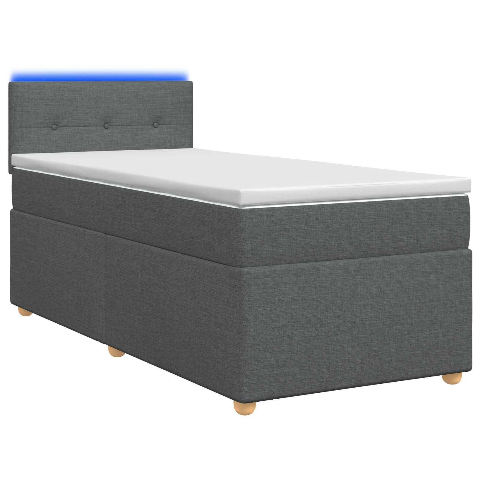 Einzelbett mit grauer gepolsterter Basis und Kopfteil, weißer Matratze und subtiler blauer Hintergrundbeleuchtung vor weißem Hintergrund.