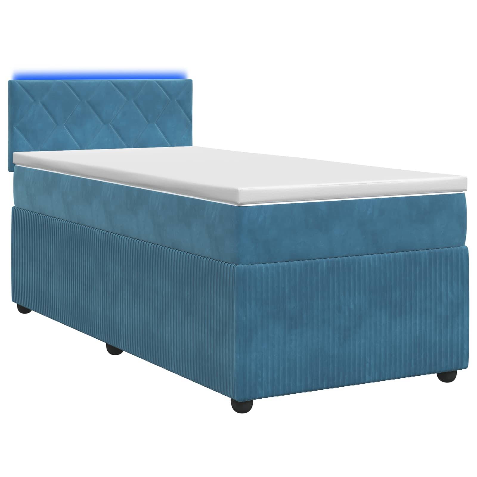 Blau gepolstertes Einzelbett mit gepolstertem Kopfteil und weißer Matratze auf weißem Hintergrund.