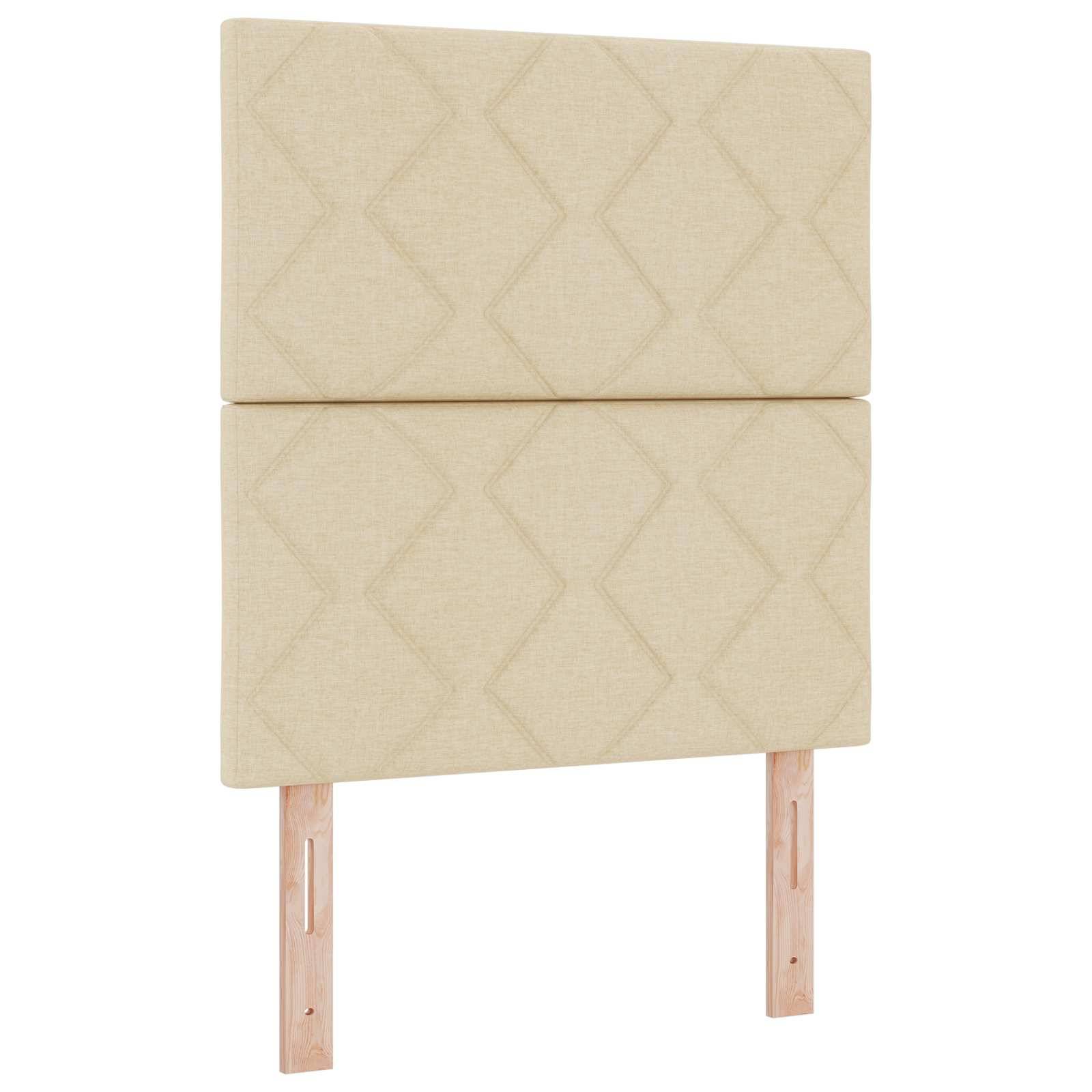 Beige gepolstertes Kopfbrett mit geometrischem Rautenmuster und zwei Holzbeinen, isoliert auf weißem Hintergrund.