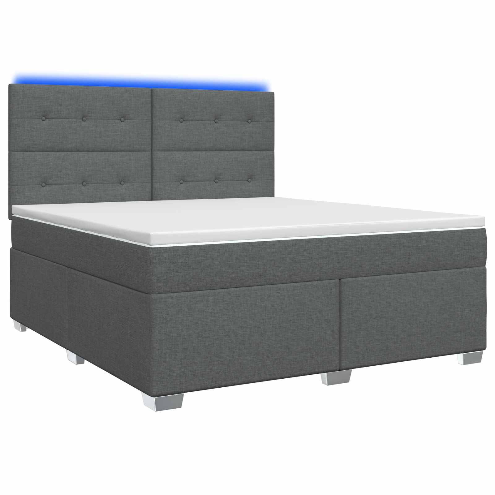 Grau gepolstertes Bett mit kapitoniertem Kopfteil mit Knöpfen, weiße Matratze und niedrige silberfarbene Beine auf weißem Hintergrund.