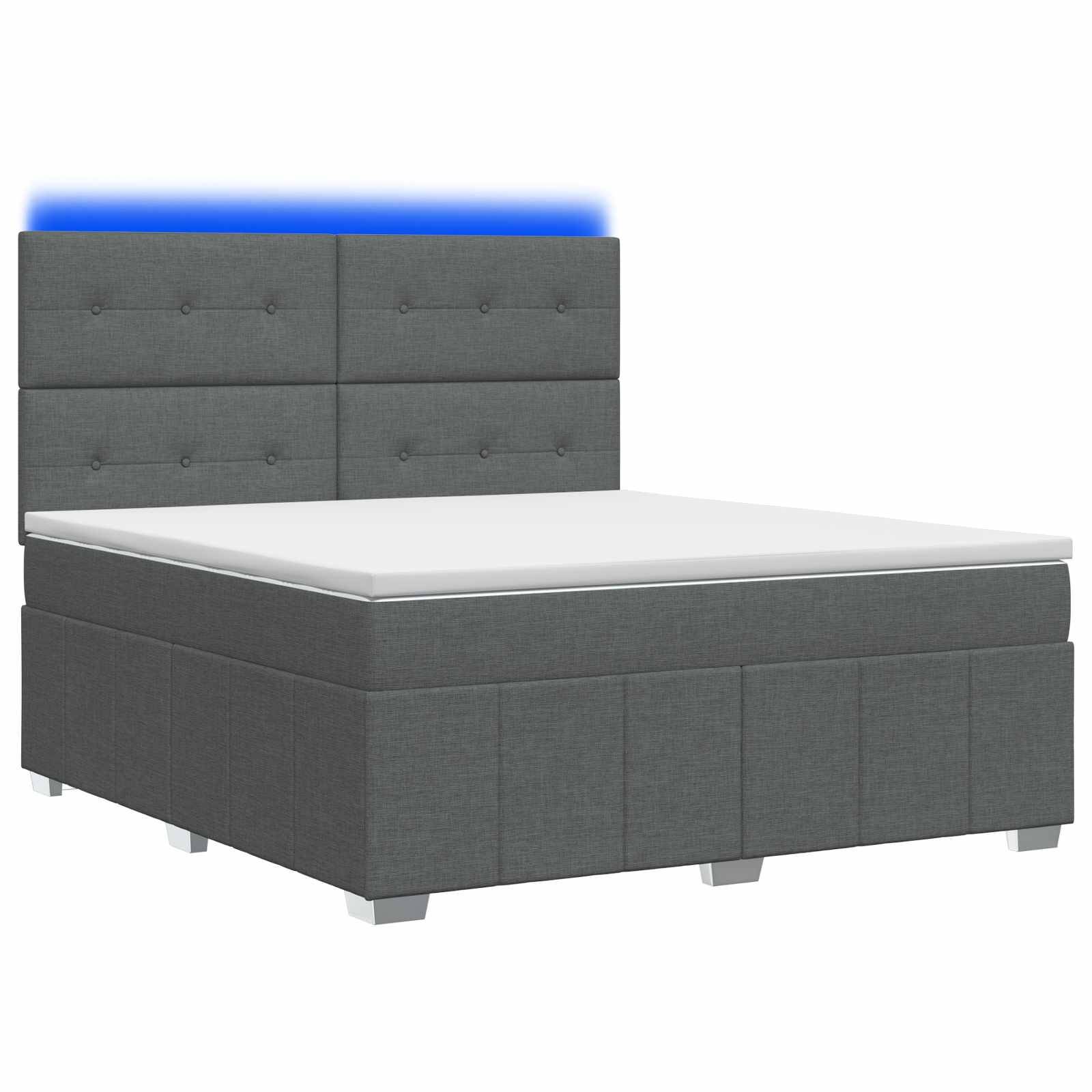 Grau gepolstertes Bett mit Knopfsteppung-Kopfteil und weißer Matratze auf einfachem weißem Hintergrund.