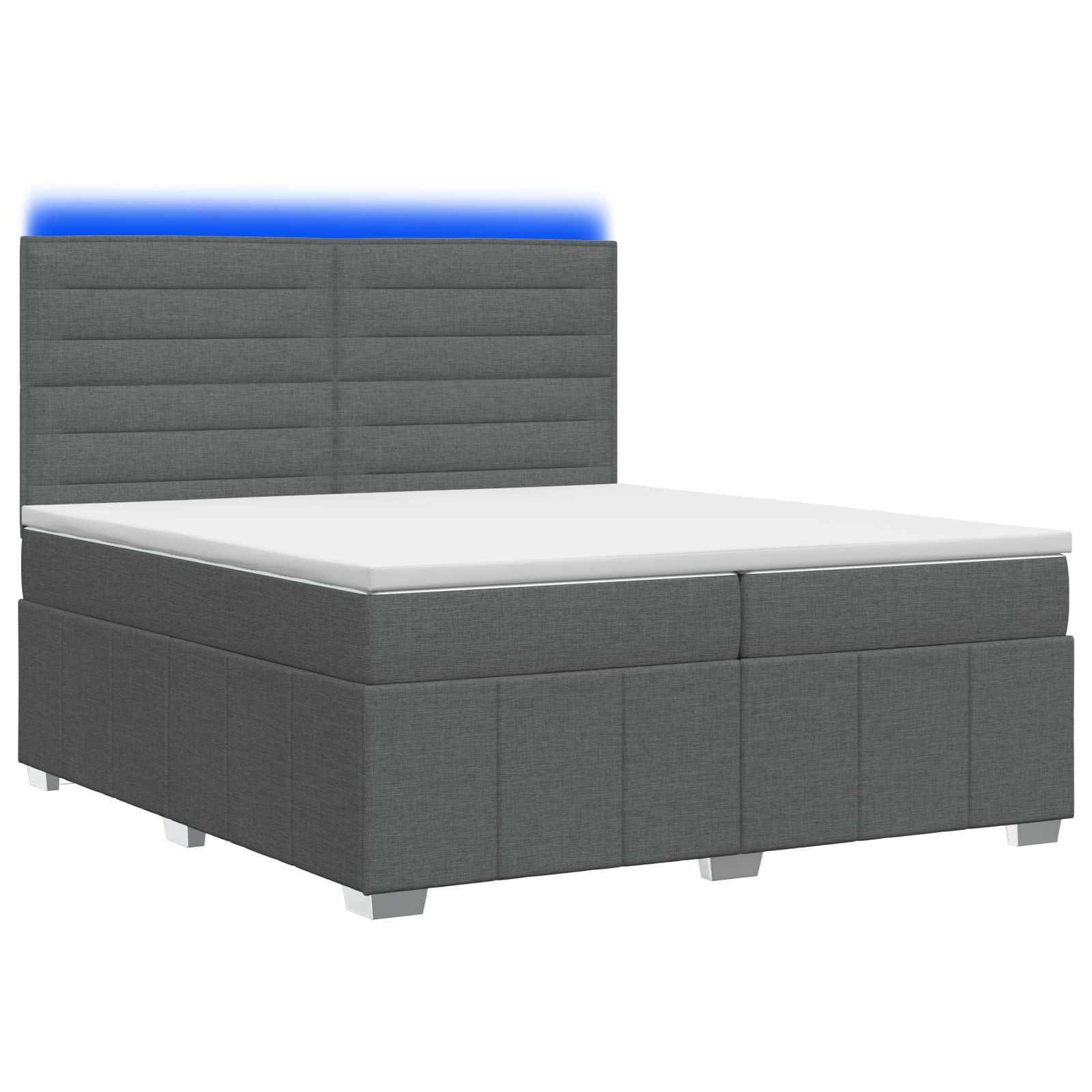 Grau gepolstertes Bett mit hohem gepolstertem Kopfteil, weißer Matratze und blauem Akzentlicht dahinter auf weißem Hintergrund.