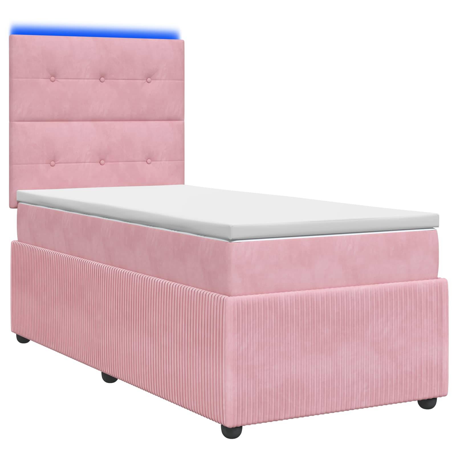 Rosa gepolstertes Einzelbett mit knopfgestepptem Kopfteil, weiße Matratze und niedriger Sockel im Lagerstil auf kleinen schwarzen Füßen.