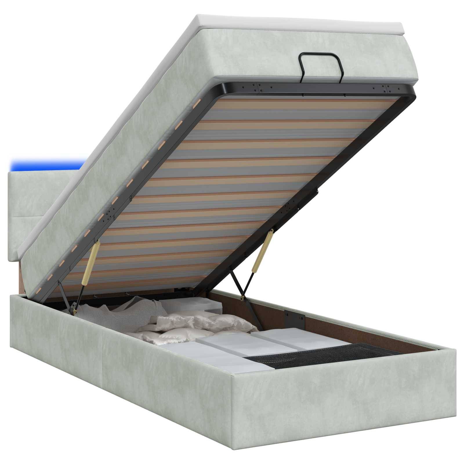 Ein gepolstertes Speicherbett mit hochgeklappter Matratzenplattform, die den Stauraum in der Basis offenbart.