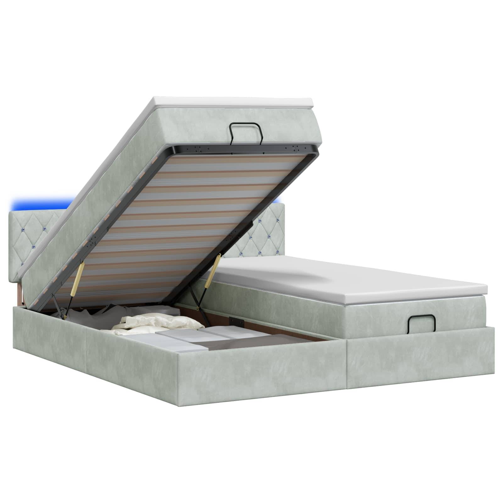 Grau gepolstertes Speicherbett mit angehobener linker Matratzenunterlage, die das Unter-Bett-Fach und die Stützleisten zeigt.
