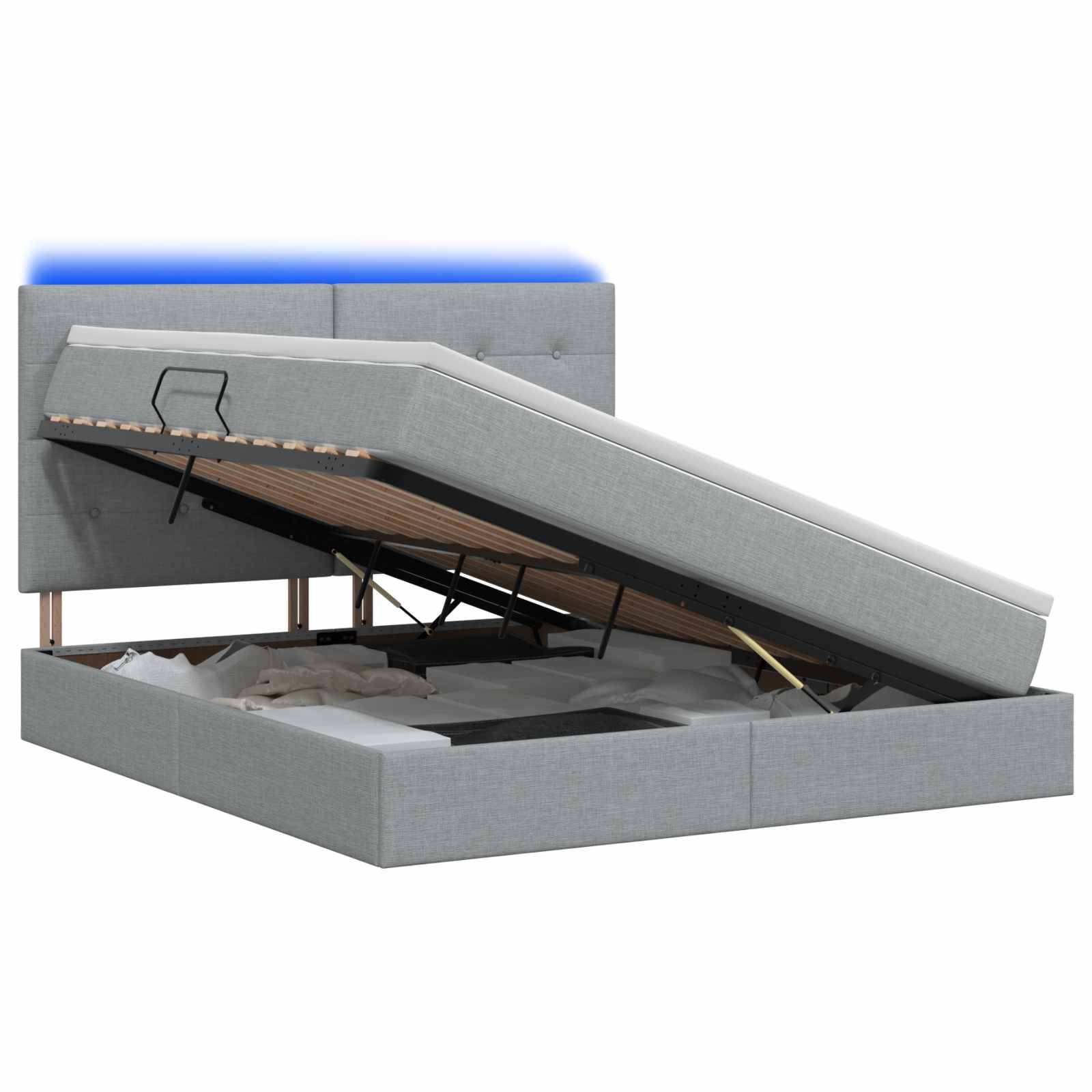 Grau gepolstertes Ottomane-Bett mit hochgeklappter Matratzenablage, die Stauraum und metallenes Stützgestell zeigt.