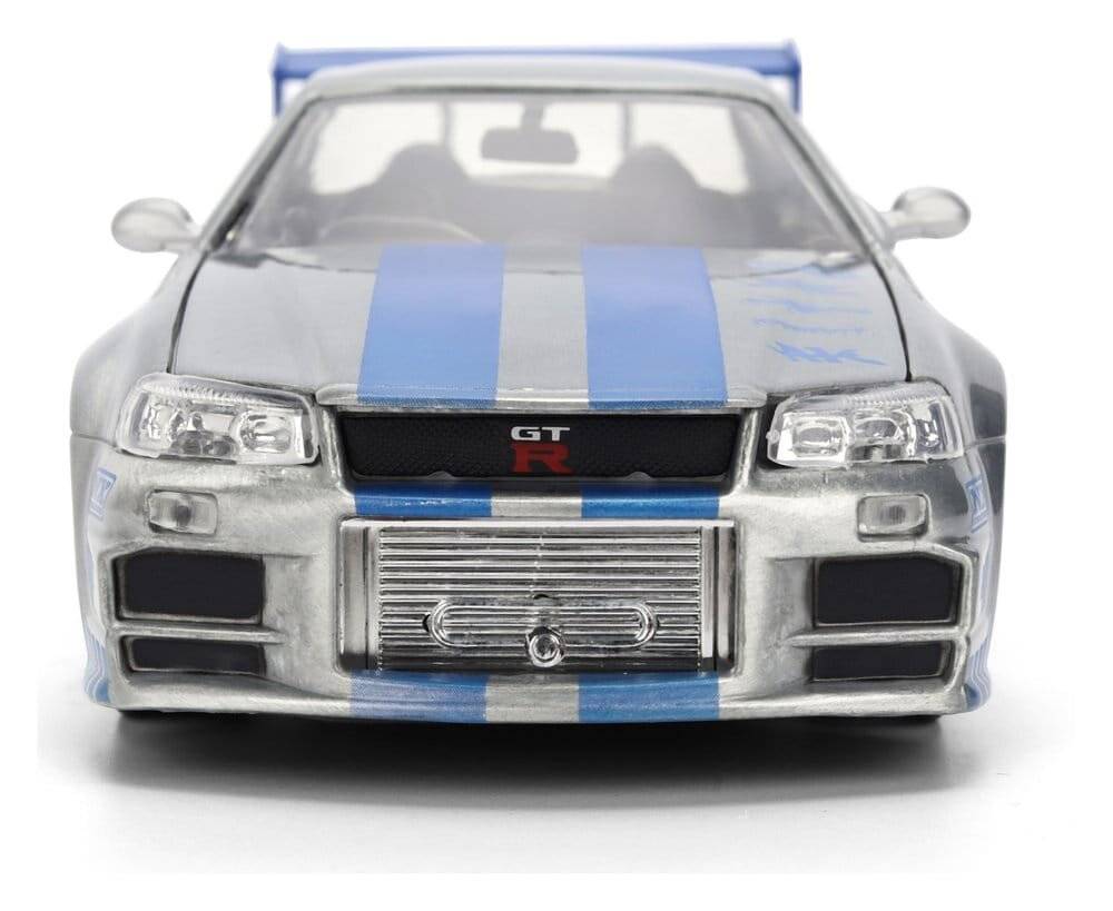 Frontansicht eines silbernen Sportwagenmodells mit blauen Rennstreifen und einem Heckflügel, das einen GT-R-Kühlergrill und Scheinwerfer zeigt.