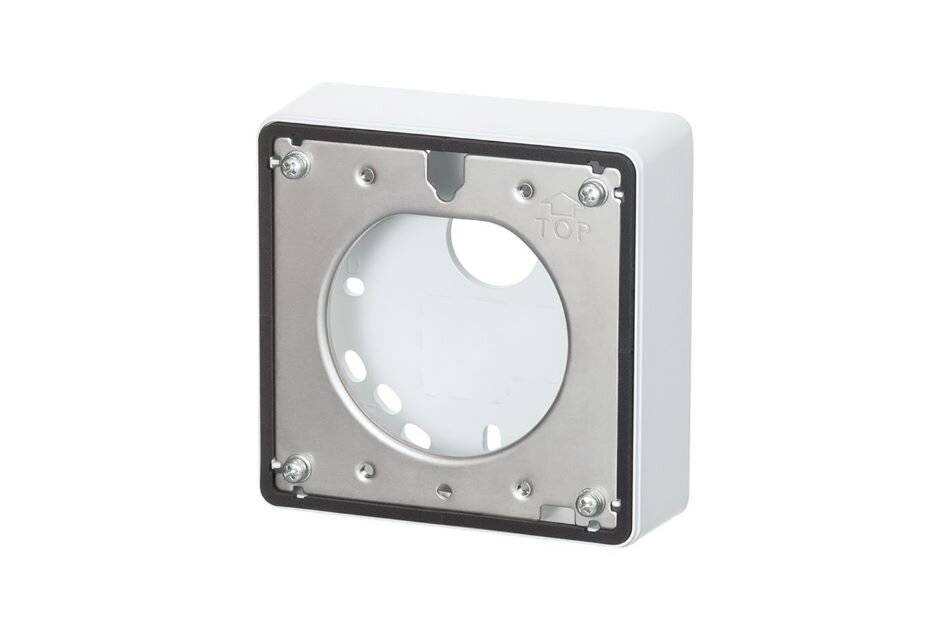 Weiße elektrische Wanddose mit quadratischem Metallmontagerahmen und kreisförmiger Öffnung, gezeigt auf einfachem Hintergrund.