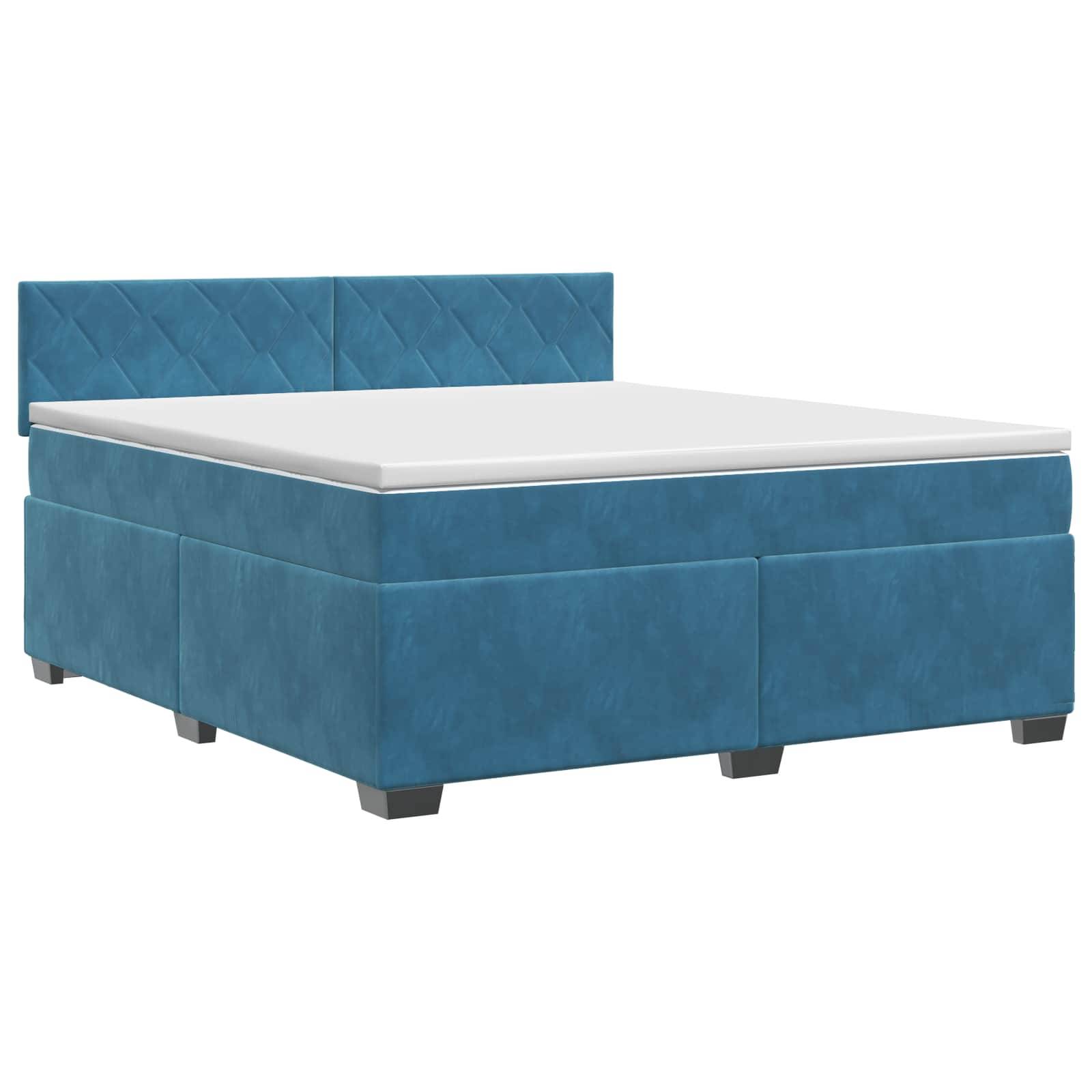 Blaugepolstertes Bett mit gestepptem Kopfteil und weißer Matratze auf einfachem weißem Hintergrund.