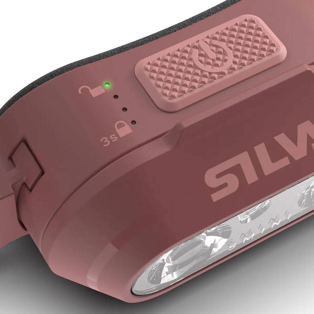 Nahaufnahme einer kastanienbraunen Stirnlampe mit einer grünen Kontrollleuchte, Schlosssymbolen, strukturierter oberer Schaltfläche und „SILVA
