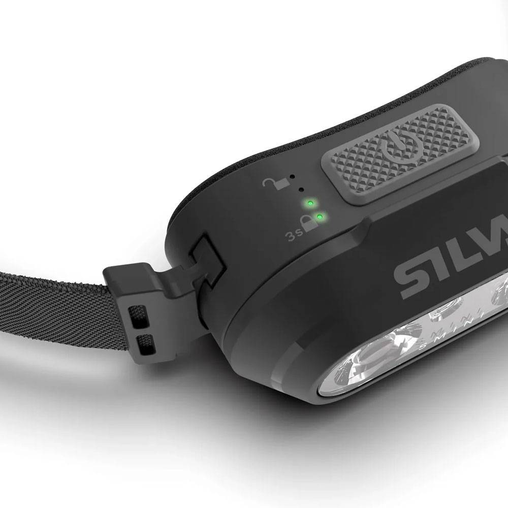 Nahaufnahme einer schwarzen wiederaufladbaren Stirnlampe mit elastischem Riemen, die Batterieanzeigen und einen strukturierten Einschaltknopf zeigt.