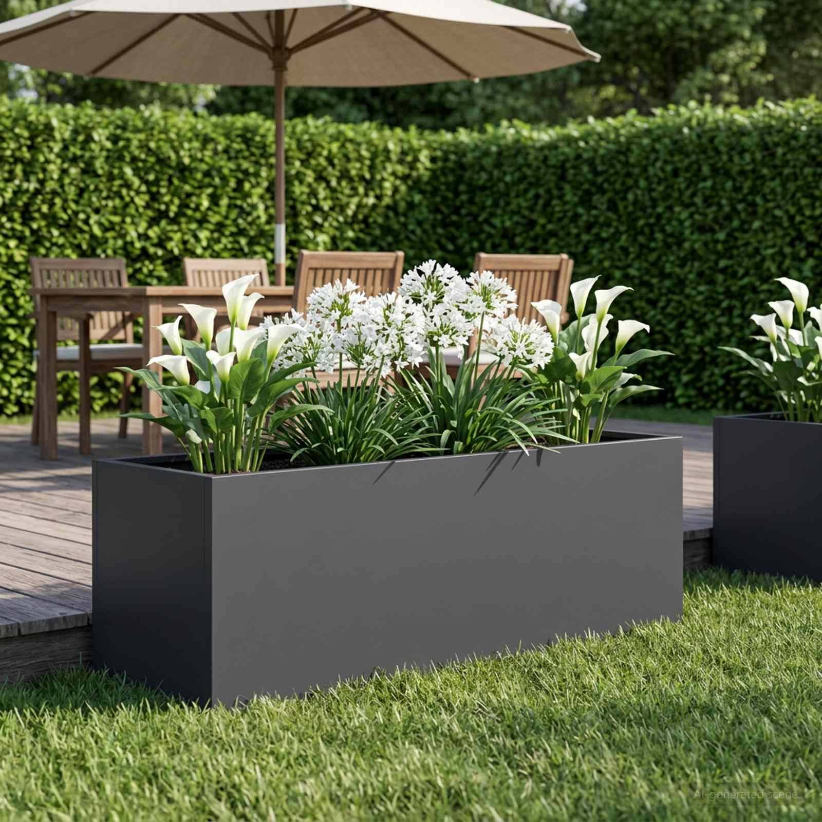 Moderner Außenbereich mit großen grauen Pflanzenkübeln, die weiße Blumen enthalten, neben einem Holztisch und einem Sonnenschirm auf einer Terrasse neben einer Hecke.