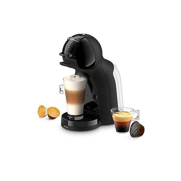 Schwarze Einzelportionen-Kaffeemaschine mit einem Latte in der Tasse und Espresso-Kapseln daneben, auf weißem Hintergrund dargestellt.