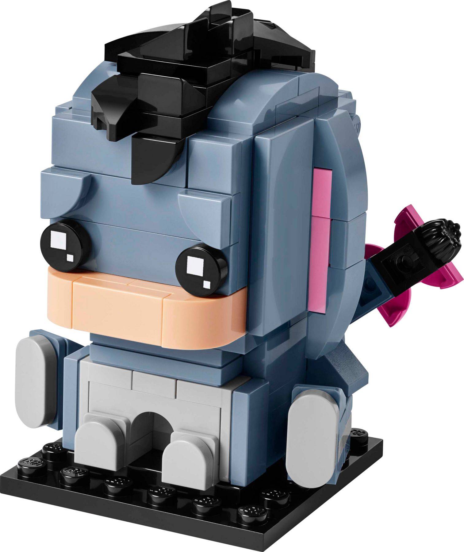 Eine LEGO-ähnliche Blockfigur eines Charakters mit blauem Haar und schwarzer Brille, der auf einer schwarzen Basis sitzt und ein rosa Accessoire auf dem Rücken hat.