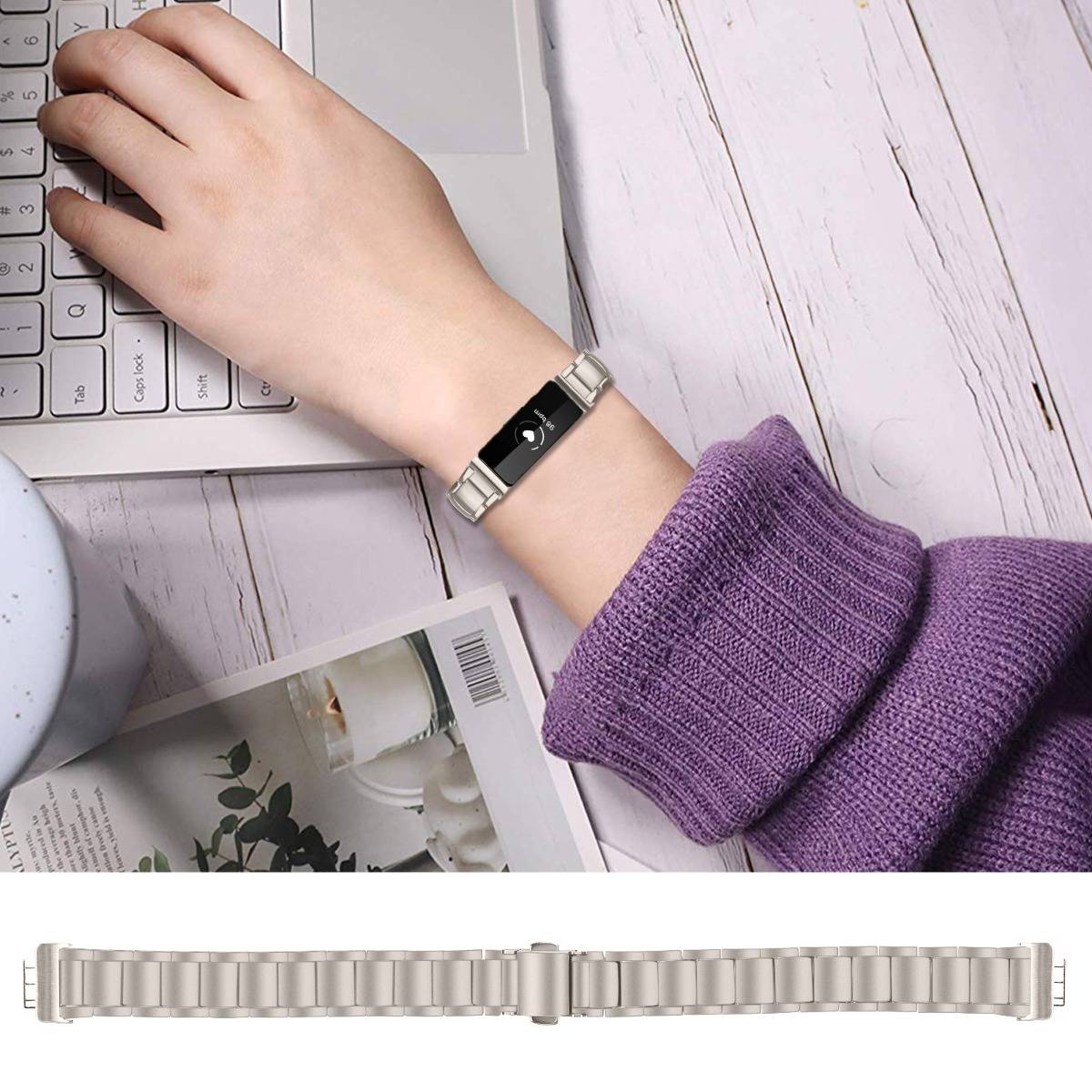 Nahaufnahme eines Handgelenks, das ein schlankes schwarzes und silbernes Smart-Armband neben einer Laptop-Tastatur trägt, mit einem passenden Metallband darunter.