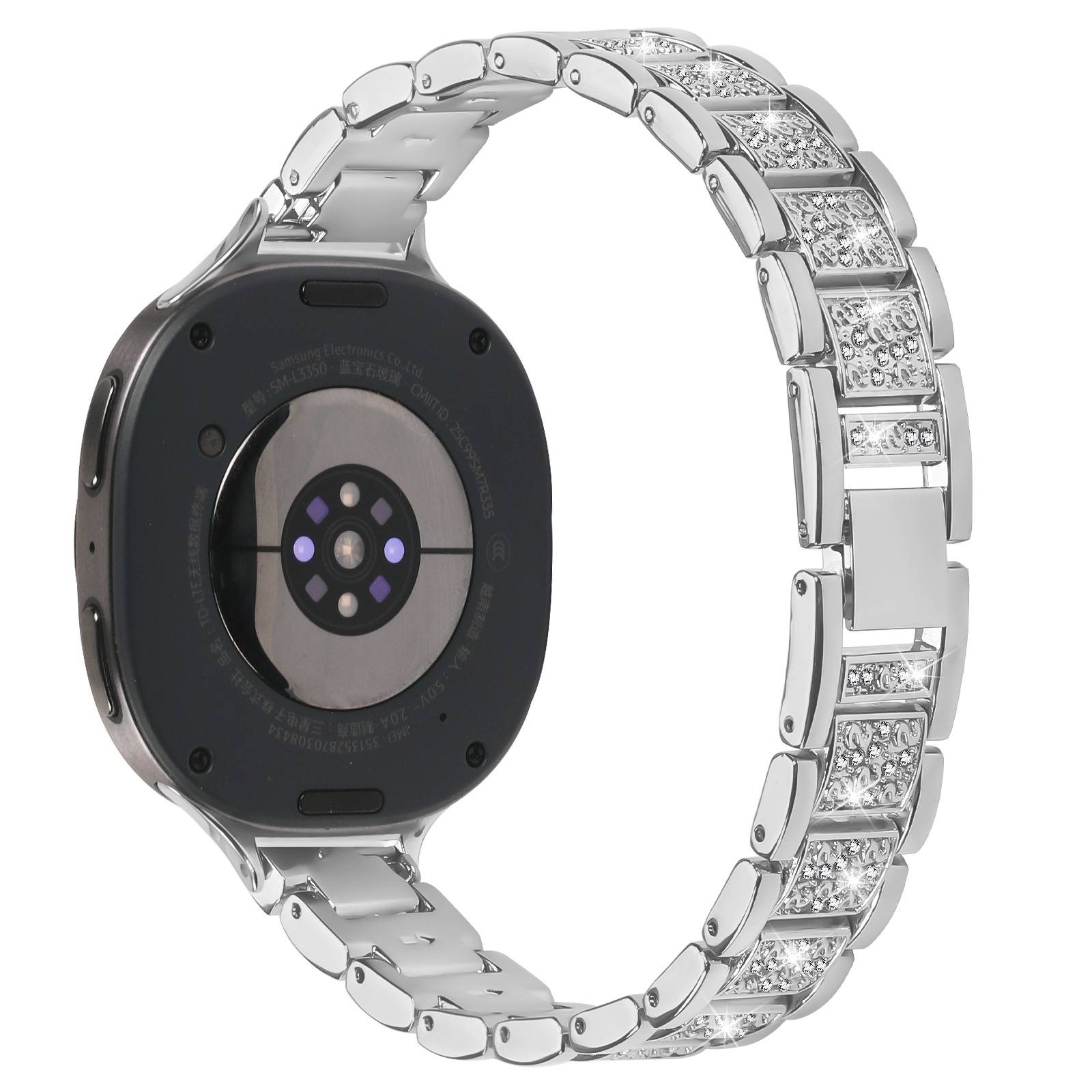 Rückansicht einer runden Smartwatch mit schwarzem Gehäuse und silbernem mit Diamanten besetztem Metallband, wobei der Sensor auf der Unterseite sichtbar ist.