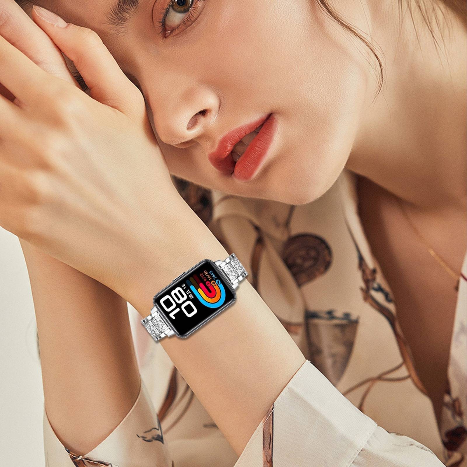 Nahaufnahme einer Frau, die eine silberfarbene Smartwatch mit einem farbenfrohen Fitness-Display trägt, während sie ihren Kopf auf ihren Händen ablegt.