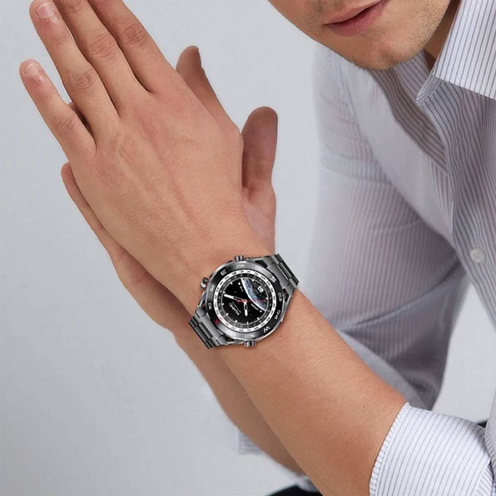 Nahaufnahme eines Mannes, der eine silberne Armbanduhr trägt, während er seine Manschette zurechtrückt, wobei die Uhr als Hauptfokus hervorgehoben wird.