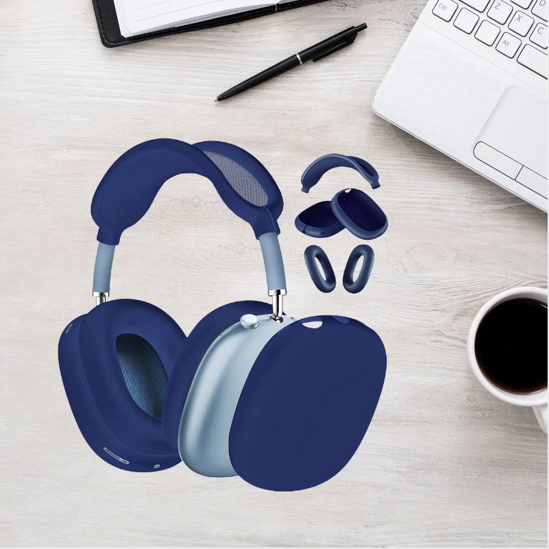 Blaue Over-Ear-Kopfhörer mit abnehmbaren Ohrpolstern auf einem Schreibtisch neben einem Laptop, Stift, Notizbuch und einer Tasse Kaffee.