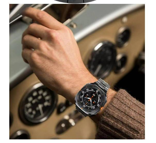 Nahaufnahme einer Hand, die einen Autoregler-Knopf verstellt, mit einer schwarzen analogen Armbanduhr mit orangefarbenen Akzenten auf einem braunen Pulloverärmel.