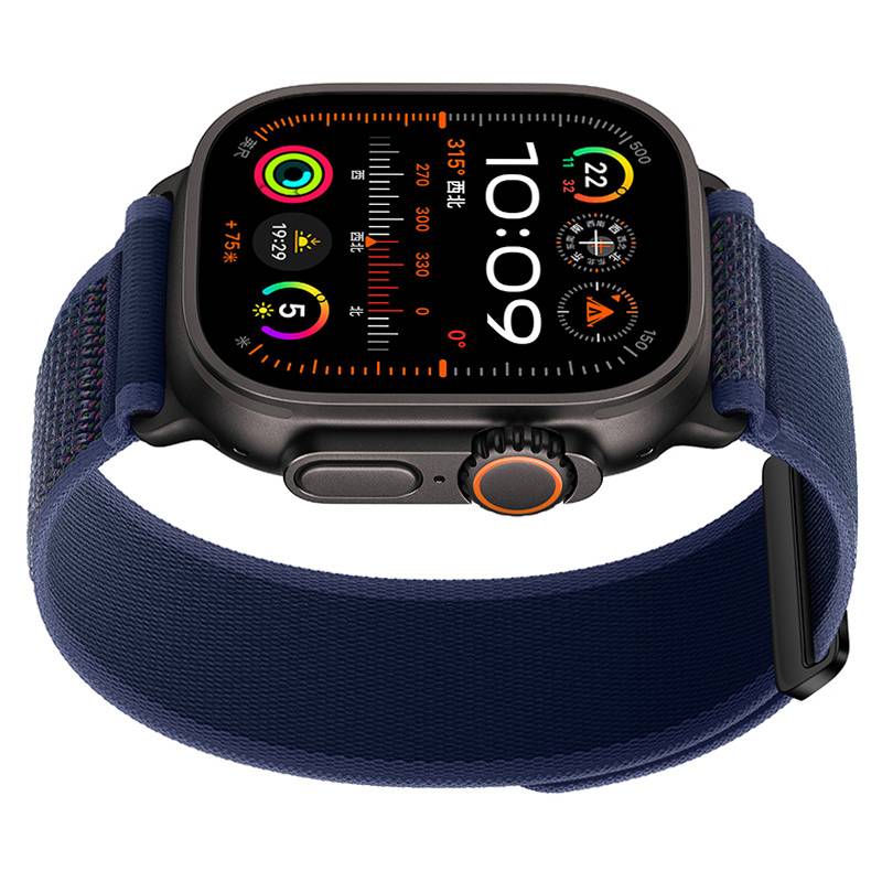 Schwarze Apple Watch Ultra mit blauem Stoffarmband, von vorne gezeigt mit Zeitanzeige 10:09 und mehreren Aktivitäts- und Kompasskomplikationen.