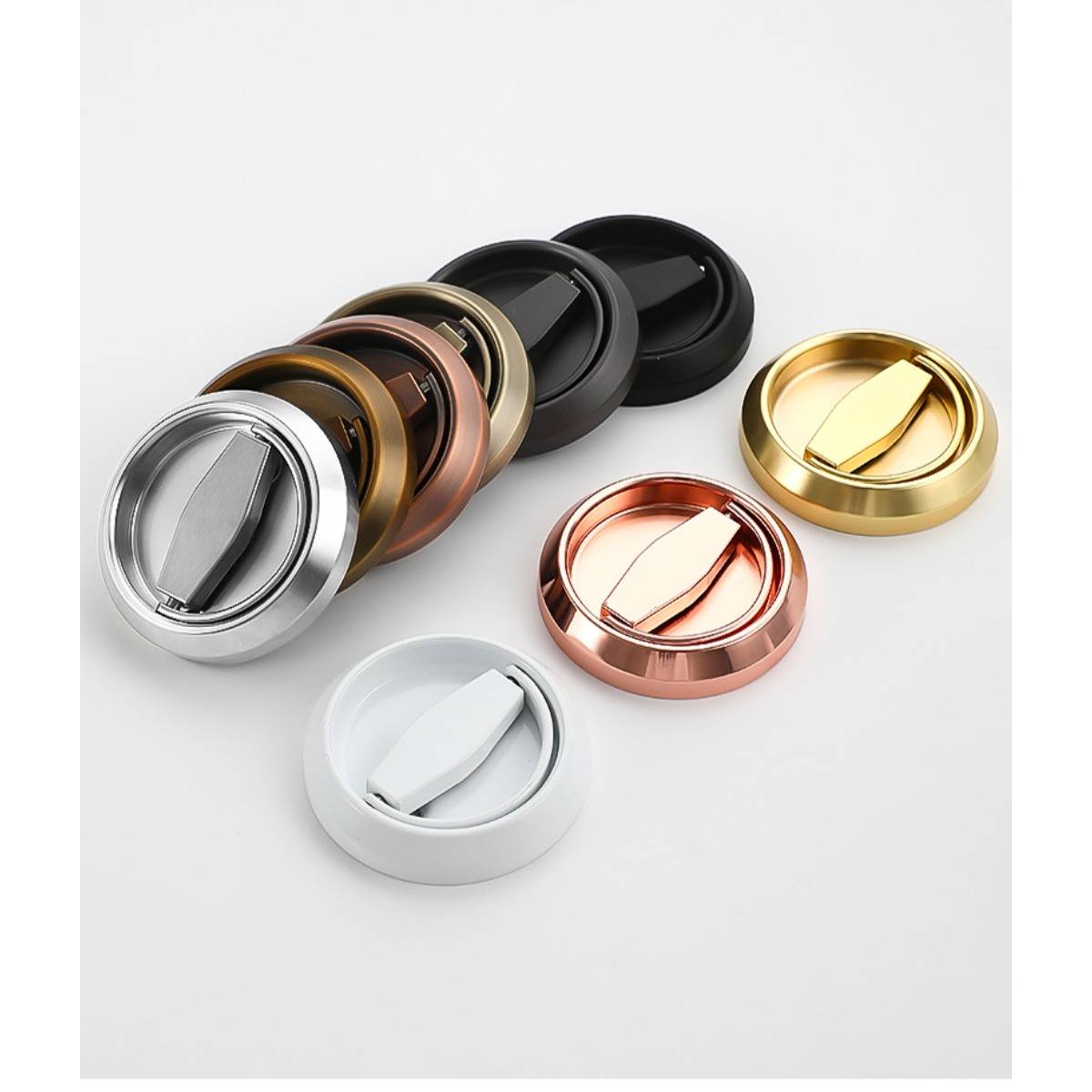 Sechs runde metallische versenkte Griffe/Knöpfe in Silber, Bronze, Schwarz, Roségold, Gold und Weiß auf hellem Hintergrund angeordnet.