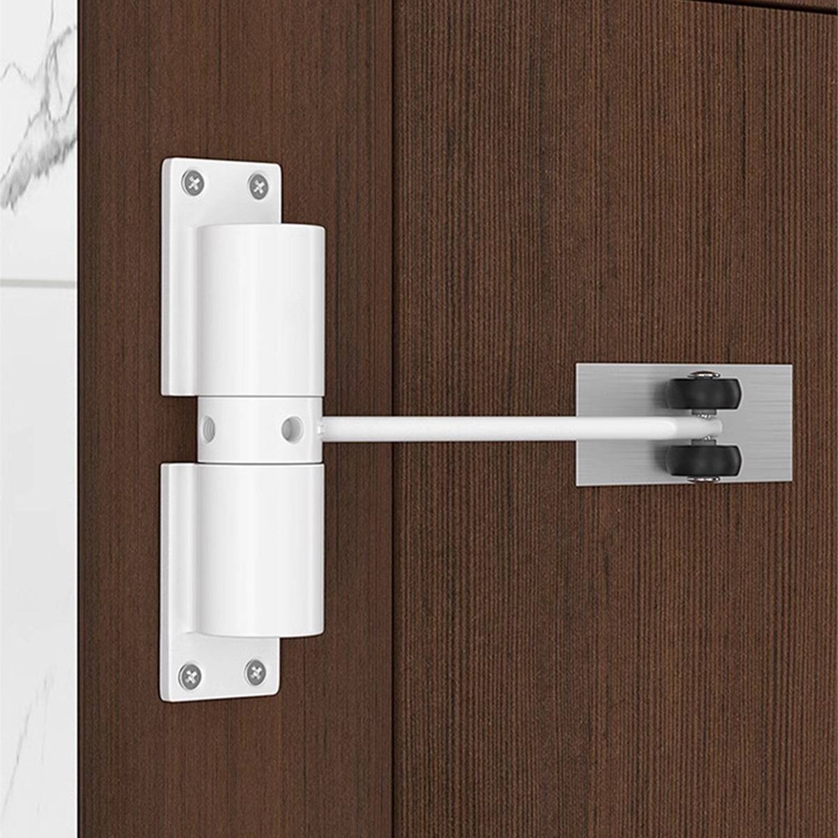 Weiß verstellbares Türscharnier mit Stützarm, das zwischen einer Wand und einem Holzschrank oder einer Türplatte montiert ist.