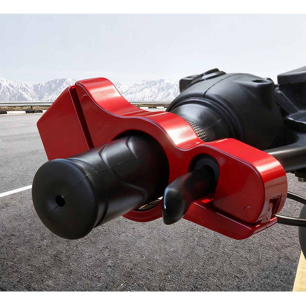 Nahaufnahme eines roten Motorrad-Anhängerkupplungsschlosses, das die Anhängekupplung sichert, mit einer Straße und schneebedeckten Bergen im Hintergrund.