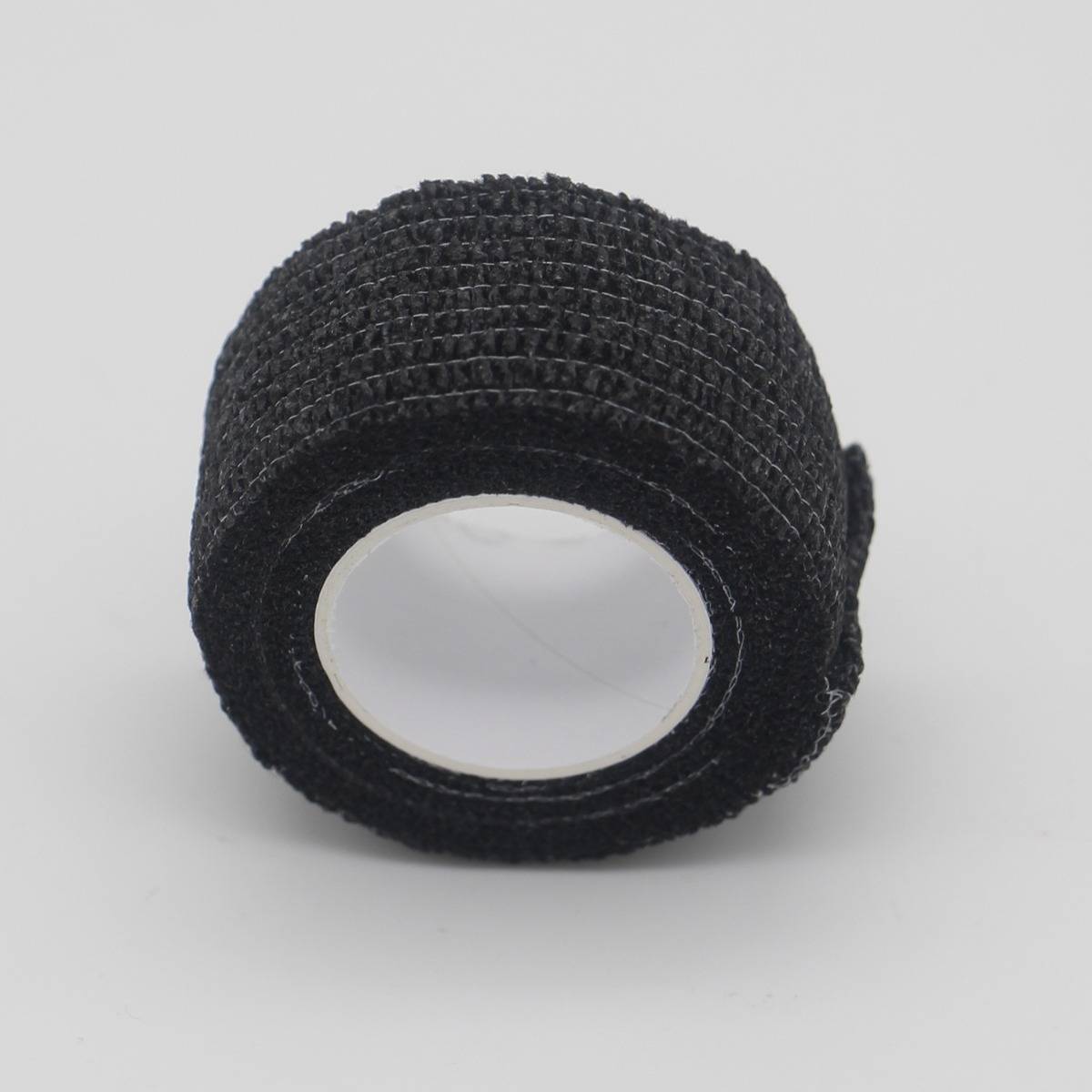 Schwarze strukturierte Klebstofffolie oder Klebeband-Rolle mit hohlem Mittelpunkt, isoliert auf weißem Hintergrund gezeigt.