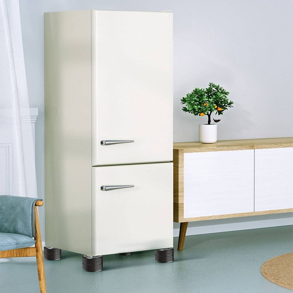 Cremefarbener Kühlschrank im Retro-Stil in einem minimalistischen Raum neben einem Holzschrank mit einer kleinen Topfpflanze.