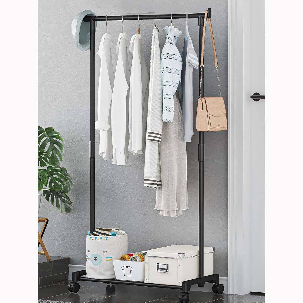 Freistehender Kleiderschrank mit weißer Kleidung, Hut, Handtasche und Aufbewahrungsbehältern in einem minimalistischen Raum.
