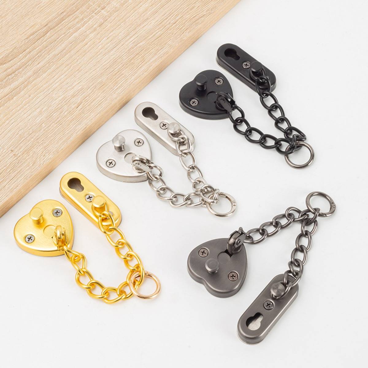 Sechs Metallkettenschlösser in Gold, Silber, Schwarz und Grau sind auf einer hellen Oberfläche angeordnet und zeigen verschiedene Oberflächenfinishes und Größen.
