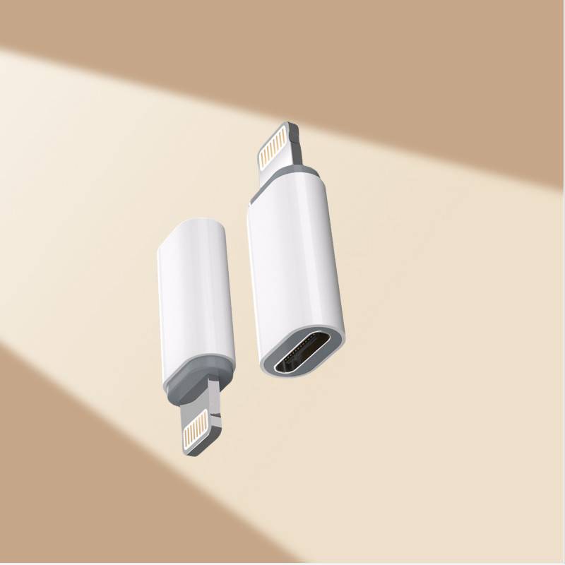 Zwei weiße USB-C-auf-Lightning-Adapter schweben auf einem beigen Hintergrund mit diagonalem Licht und Schatten.