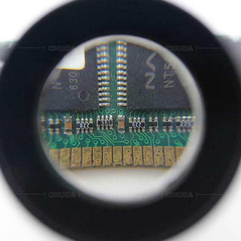 Nahaufnahme durch ein Mikroskoplinseneines Leiterplattenchips mit winzigen Komponenten und goldenen Kontakten, die detaillierte elektronische Bauteile und Lötstellen zeigen.