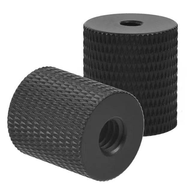 Zwei schwarze geriffelte zylindrische Knöpfe mit Mittellöchern, dargestellt auf einem einfachen weißen Hintergrund.