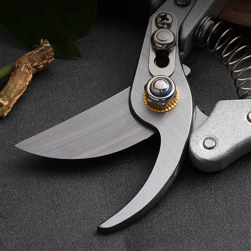 Nahaufnahme eines Klapptaschenmessers mit einer teilweise geöffneten, geschwungenen silbernen Klinge und Metallgriff, auf einer dunklen Oberfläche dargestellt.