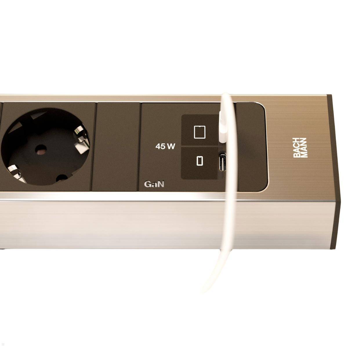 Silberne Steckdosenleiste mit schwarzem Steckdosenanschluss und USB-Anschlüssen, gekennzeichnet mit 