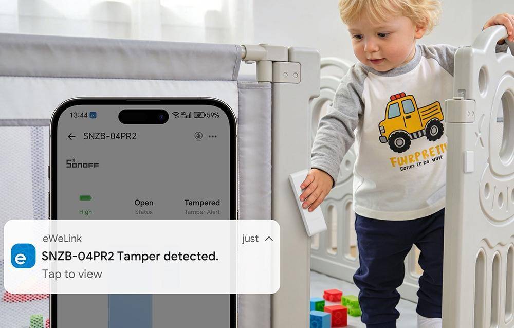Ein Kleinkind steht neben einem Kinderbett, während ein Telefon eine eWeLink-Benachrichtigung anzeigt: „SNZB-04PR2 Manipulationserkennung erkannt. Zum Anzeigen tippen.