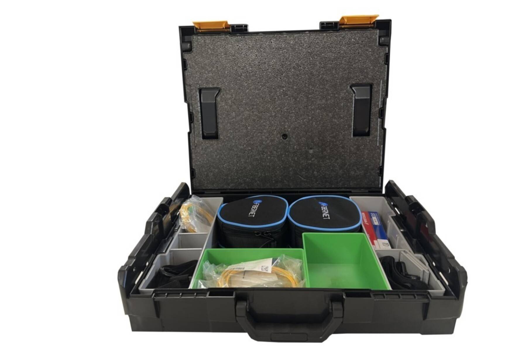 Offener schwarzer Lagerungskoffer mit Schaumstoffauskleidung, der zwei kleine blau-schwarze Taschen und verschiedene gepackte Werkzeuge oder Teile in grünen und durchsichtigen Fächern enthält.