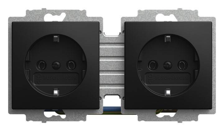 Zwei schwarze elektrische Wandsteckdosen nebeneinander auf einem Metallrahmen montiert.